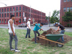 Youth Shoveling Soil to Prepare Land