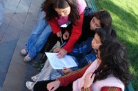Girls learning about birds on bench in the park