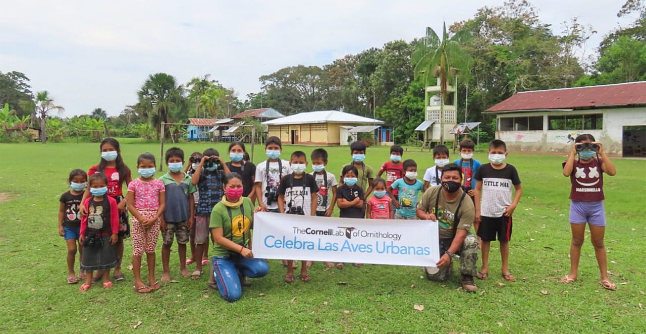 Kids line up in front of a sign that says 