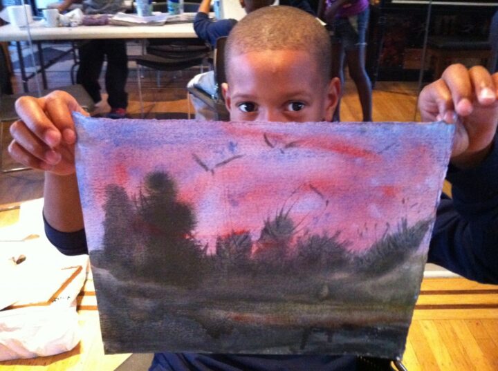 A boy displays landscape art he created