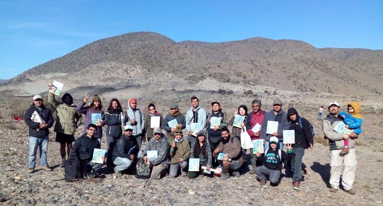 People line up for a photo while holding a book